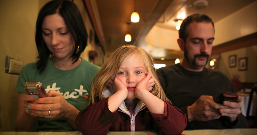 Young girl ignored by her parents, looking bored