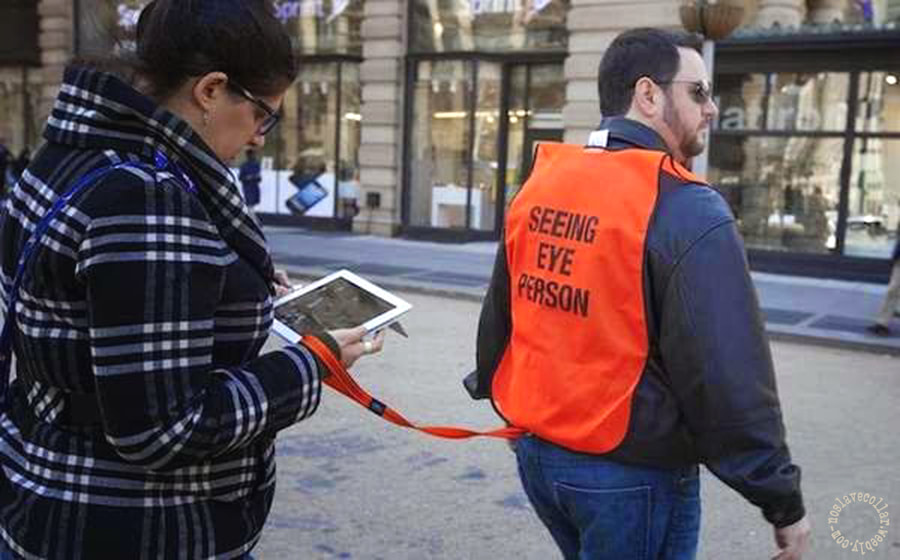 A high visibility jacket with a leash, reading 'Seeing Eye Person'